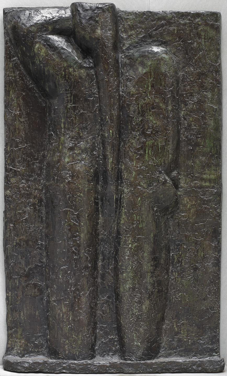 This sculpture features two rough, vertical, elongated forms side by side against a flat background. The figures are predominantly dark brown with hints of green. This is an AI generated description. To give feedback, email ai@moma.org.