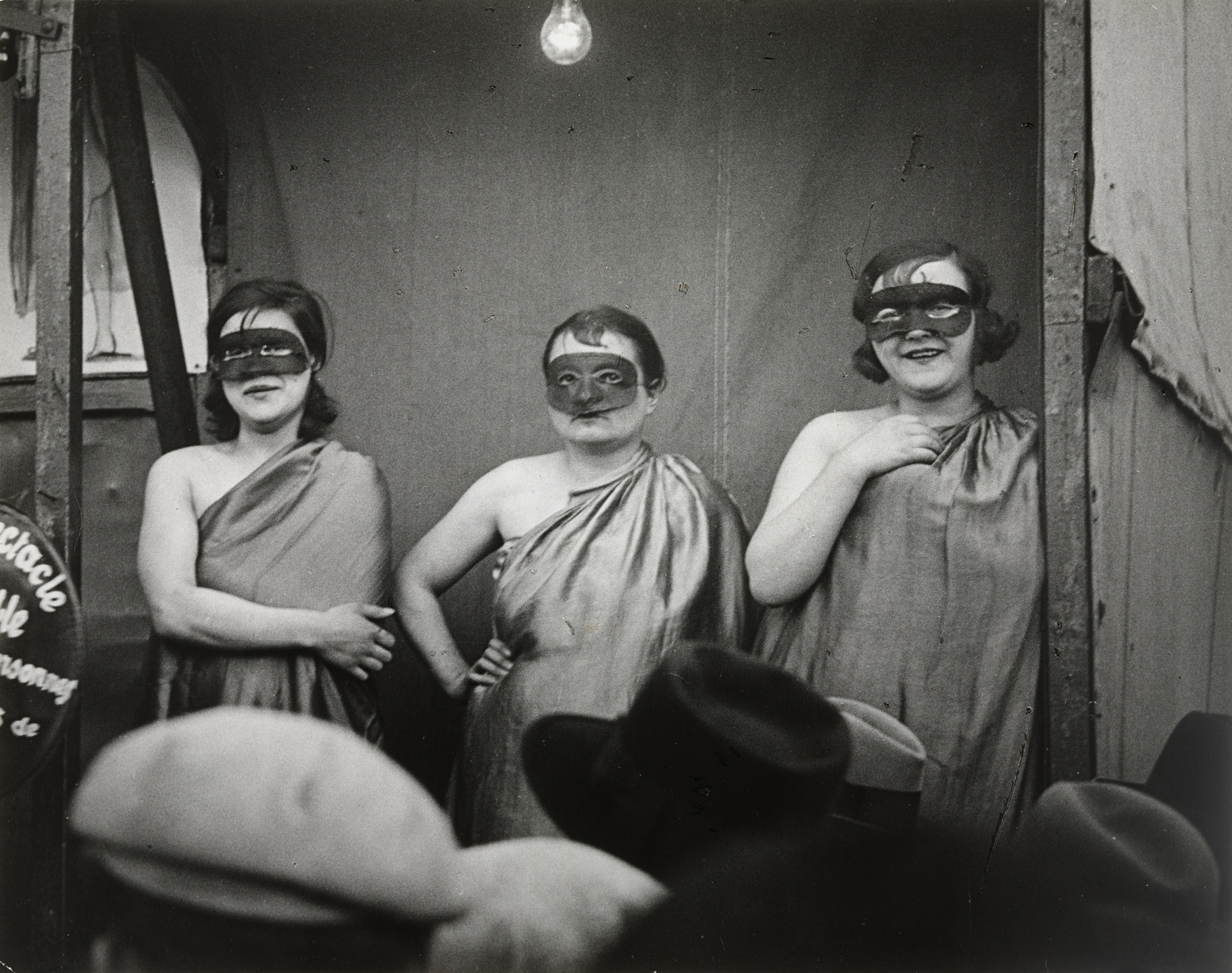 Brassaï (Gyula Halász). Three Masked Women in Front of Their Booth, Boulevard Saint-Jacques. 1931