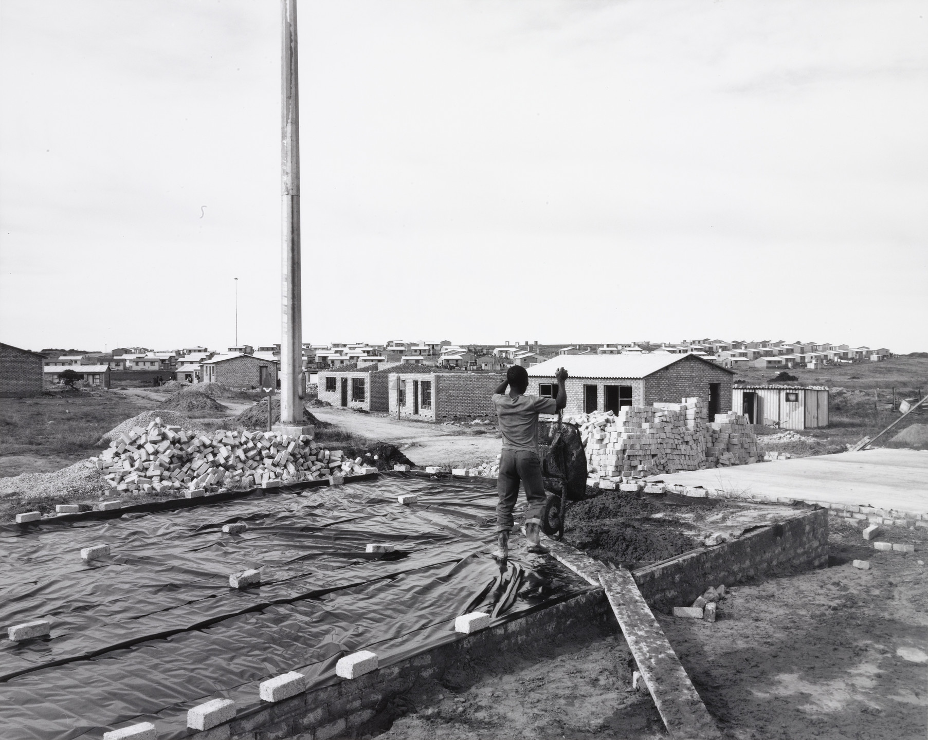 David Goldblatt. A Man Building His House on His Own Plot of Ground, Marselle Township, Kenton-on-Sea, Eastern Cape. 8 July 1990