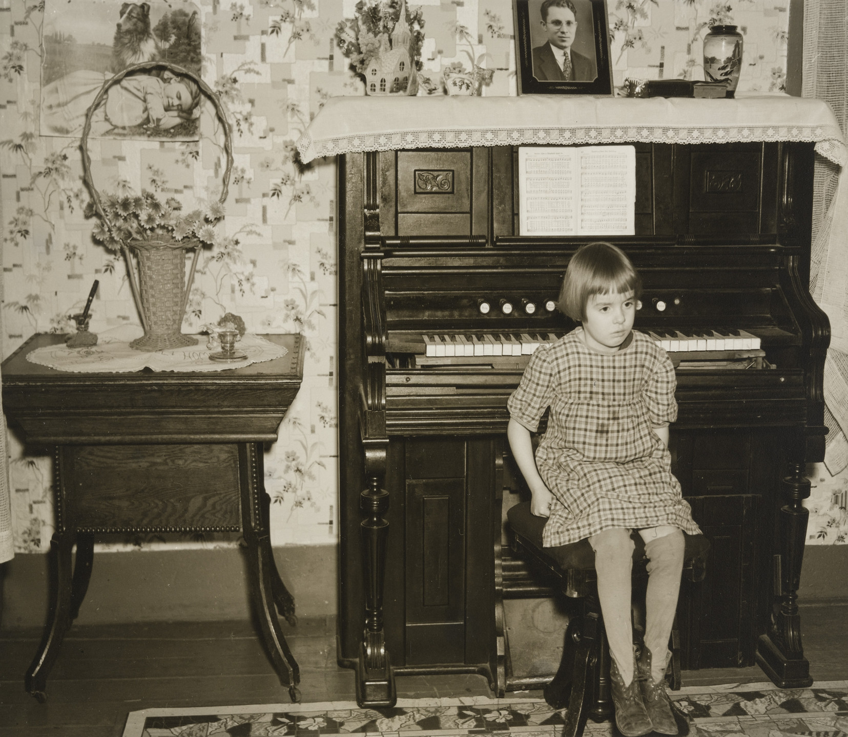 Russell Lee. After Dinner the Family Sits Around the Living Room. This is one of the Daughters Sitting on the Stool for the Organ. March 1937