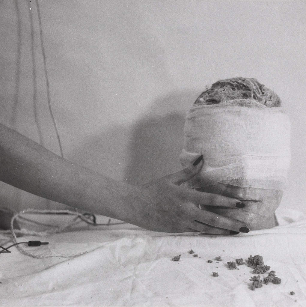 4th Action, (woman's hand touching wrapped head)