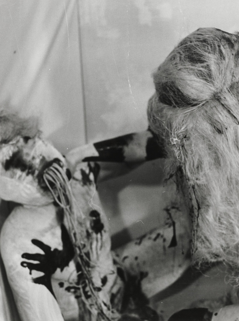 (wigged man grabbing gagged man)