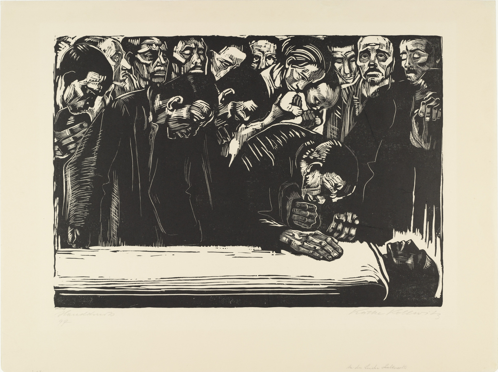 A group of individuals, primarily in dark attire, gather around a white horizontal surface, with several bowing their heads. The scene is predominantly in black and white. This is an AI generated description. To give feedback, email ai@moma.org.