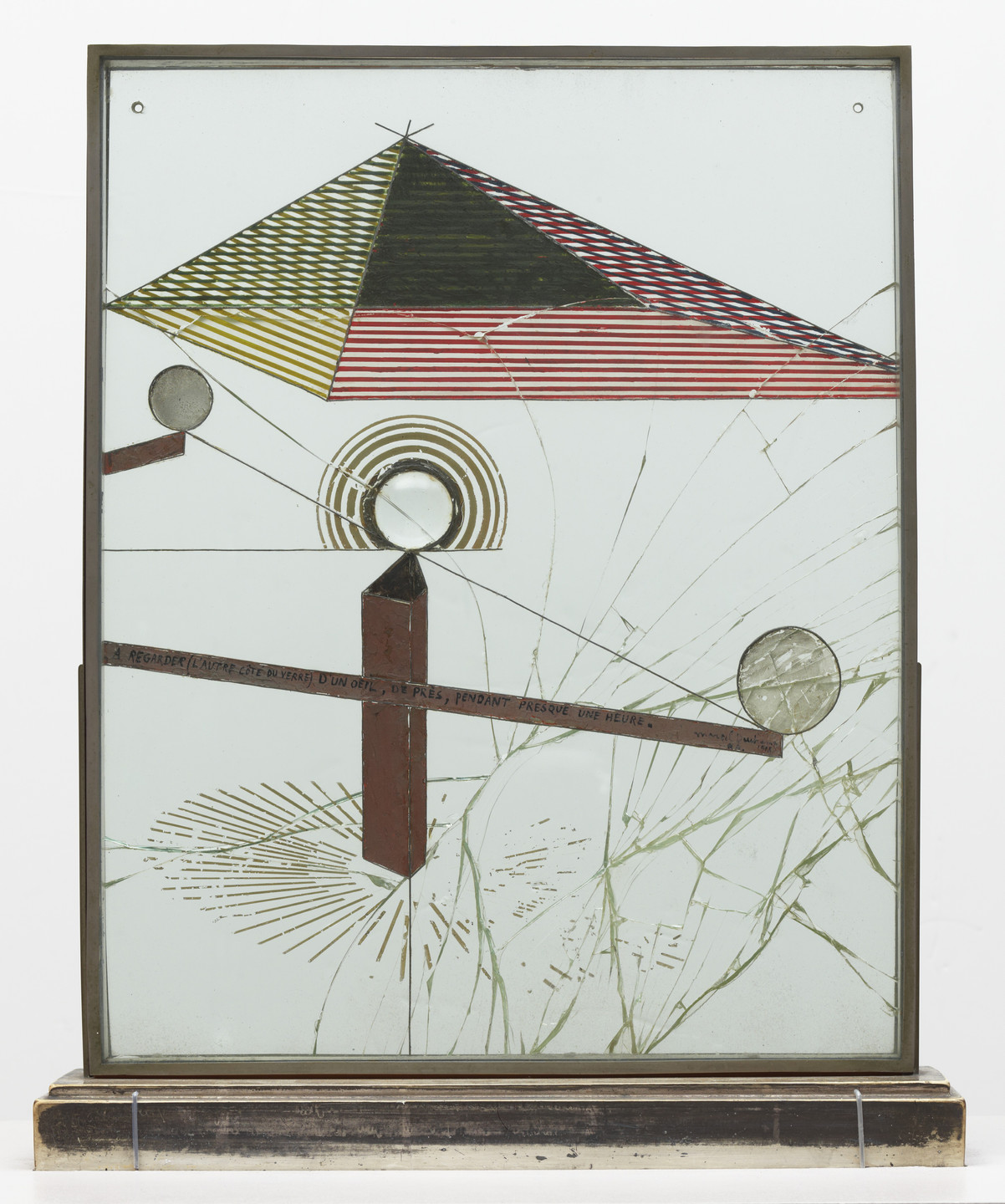The image features a metal frame with various geometric shapes and lines, including a red and black triangular shape, circular elements, and green and red diagonal lines on a light background. The design includes text in a foreign language and has lines radiating from some shapes. This is an AI generated description. To give feedback, email ai@moma.org.