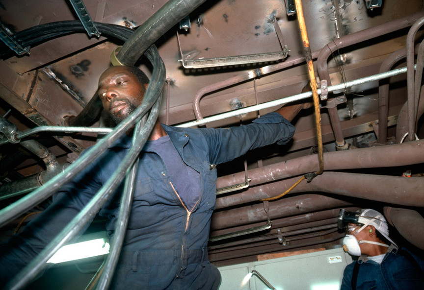 Allan Sekula. Pipe fitters finishing the engine room of a tuna-fishing boat. Campbell Shipyard. San Diego harbor from the series Fish Story. August 1991