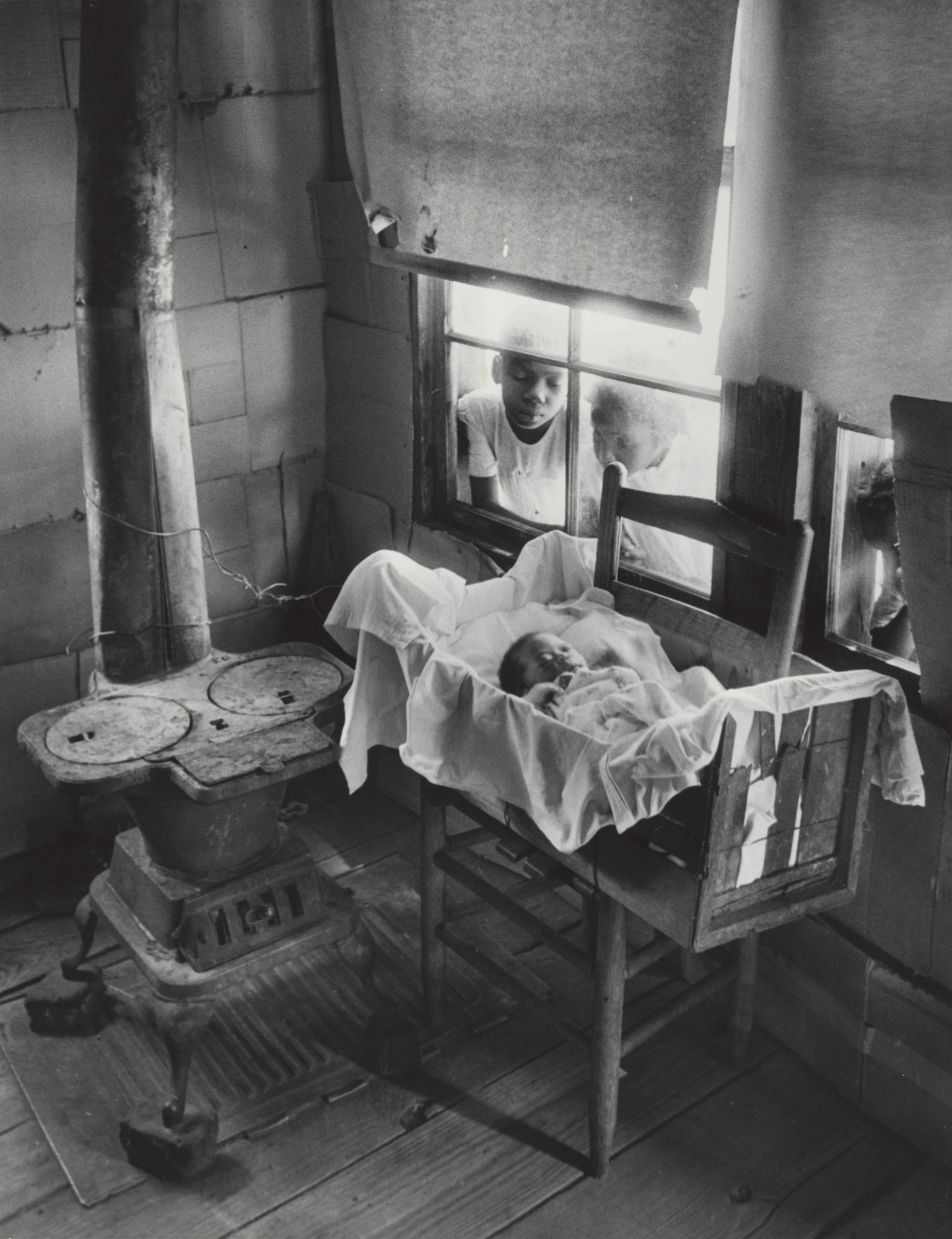 W. Eugene Smith. Newborn Baby in Makeshift Crib near Cold Stove