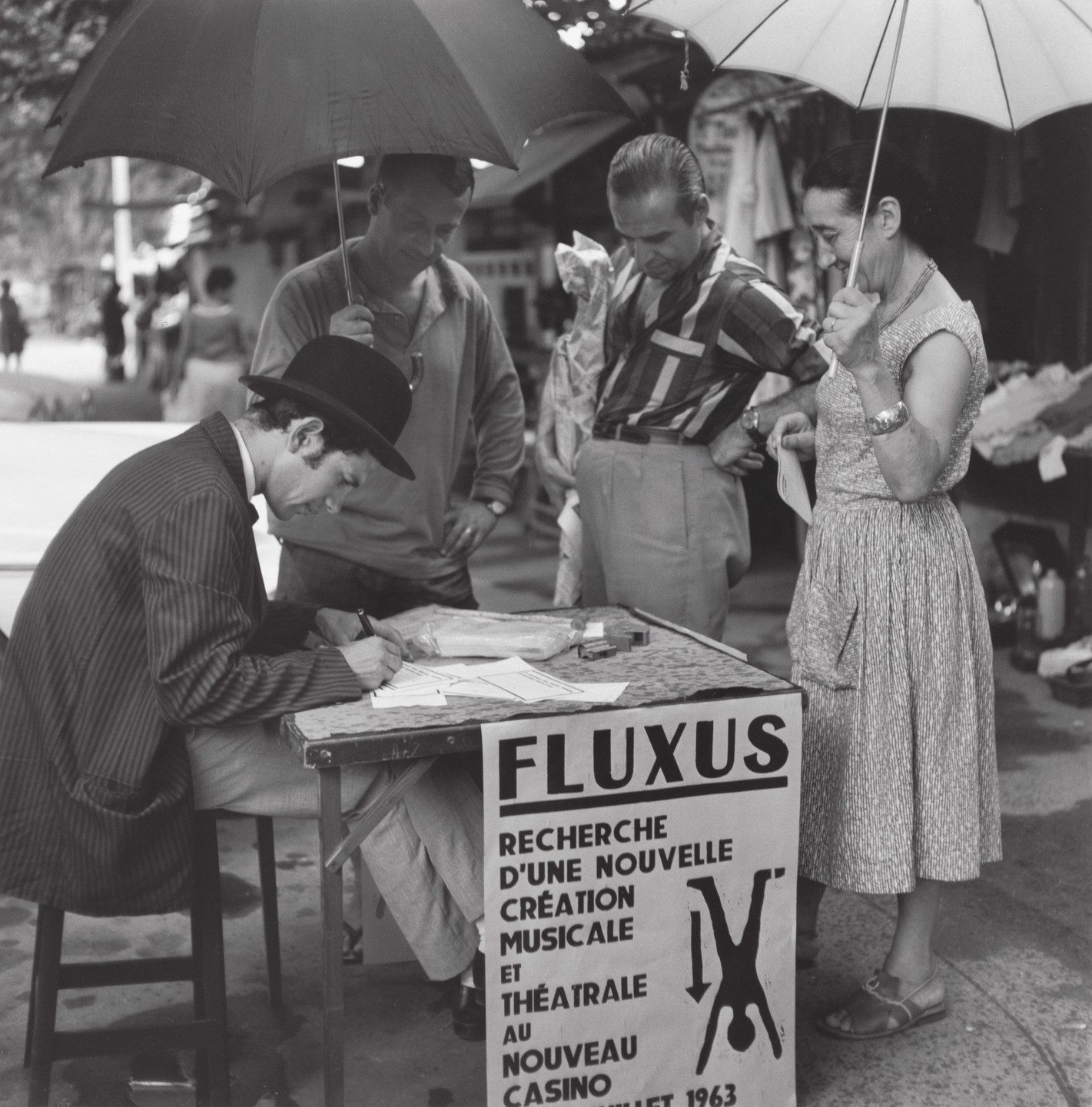 Ben Vautier. Signing certificates, performed during Fluxus Festival of Total Art and Comportment, Flea market, Nice, July 25, 1963. 1963