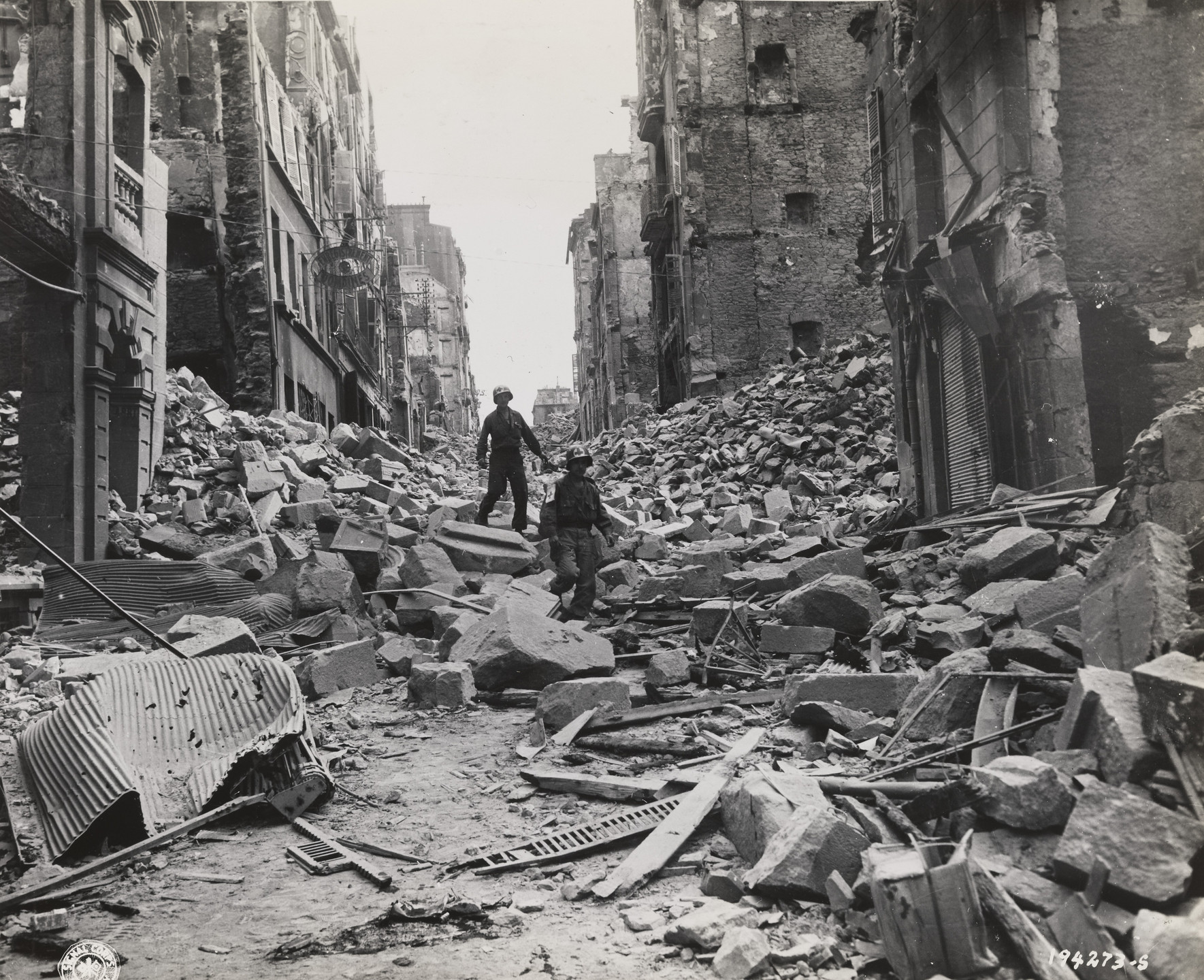 U.S. Army Signal Corps. Untitled ("Two army first aid men search through the wreckage in the streets of Brest, France, for injured"). September 19, 1944