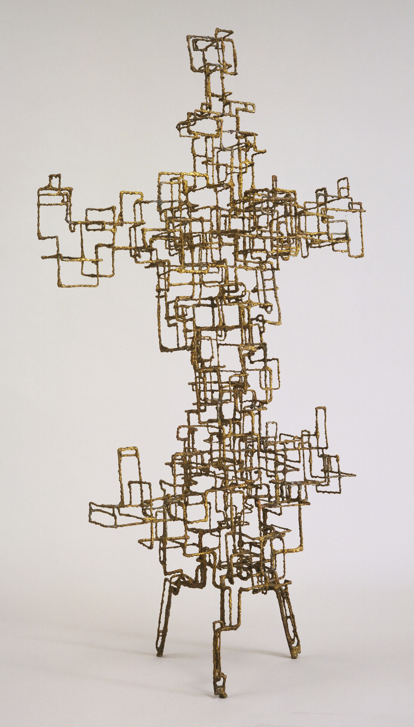 A metallic sculpture composed of interconnected rectangular and square golden frames, forming a complex, lattice-like structure. The sculpture stands on three thin legs and contrasts against a plain, light-colored background. This is an AI generated description. To give feedback, email ai@moma.org.