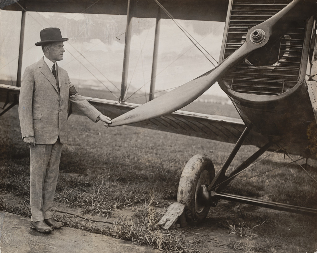 "President Coolidge Wears His Rubbers to Inspect One of the Round-the-World Planes on Their Arrival at the Capital"