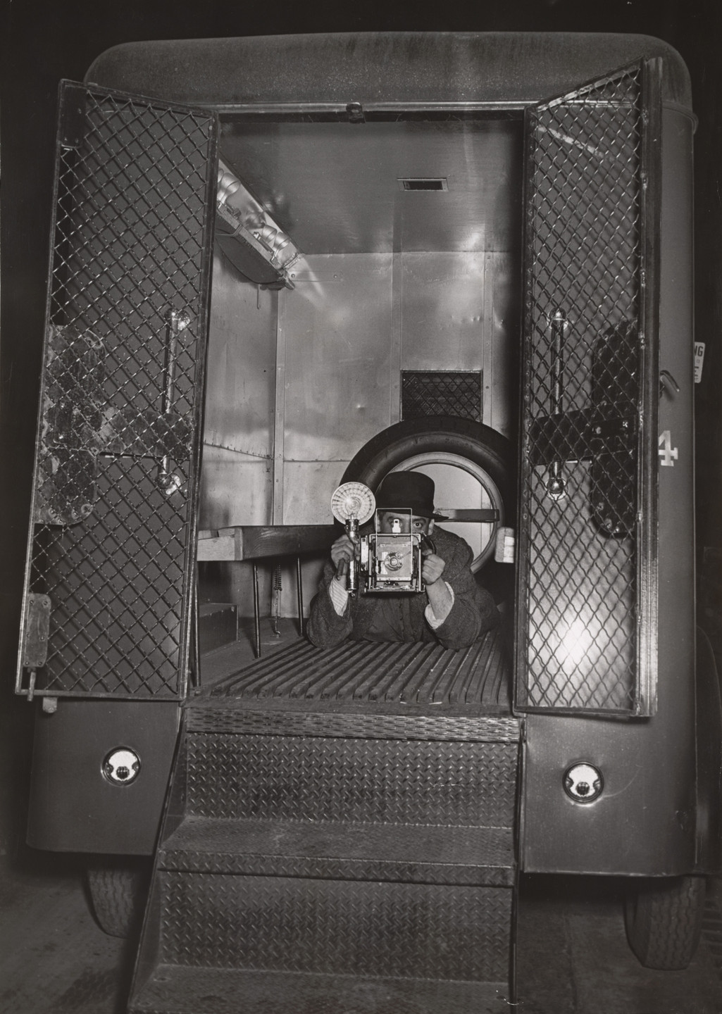 Weegee (Arthur Fellig). Self Portrait in Police Van. c. 1940