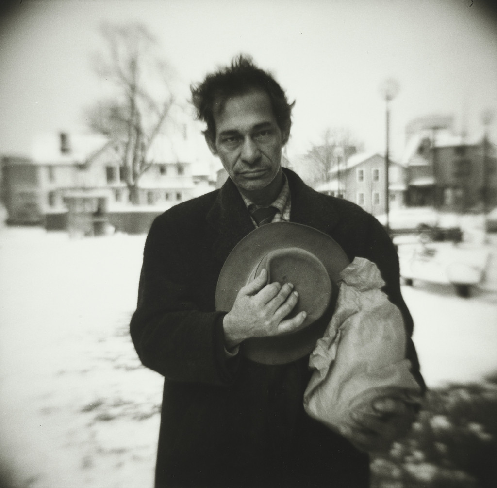 Man Holding Hat and Wine Bottles
