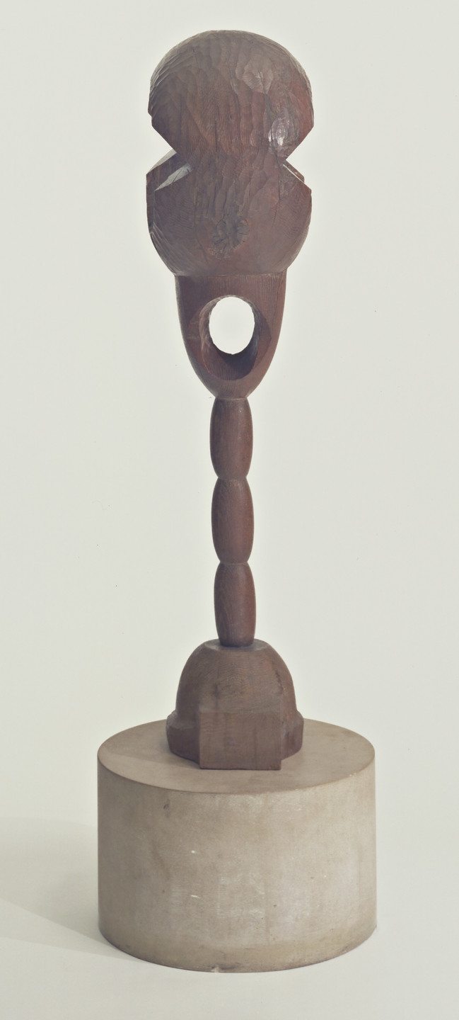 A wooden sculpture with an oval, textured top and a rounded, segmented stem, standing on a smooth, cylindrical base. Predominant colors are brown for the sculpture and gray for the base. This is an AI generated description. To give feedback, email ai@moma.org.