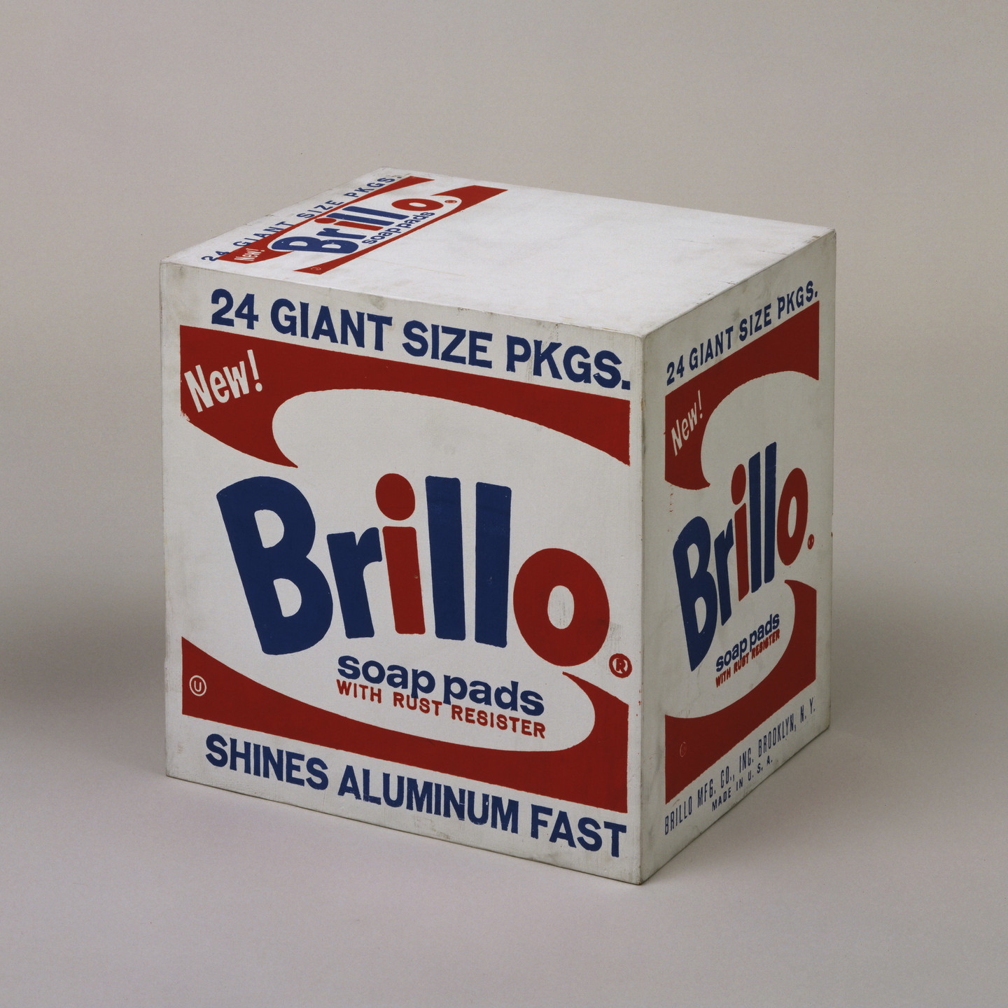 A white box displays &#34;Brillo&#34; in large blue letters with a red dot for the &#34;i&#34; and various text in smaller red and blue font. Text includes &#34;24 Giant Size Pkgs&#34; and &#34;Shines Aluminum Fast.&#34; This is an AI generated description. To give feedback, email ai@moma.org.