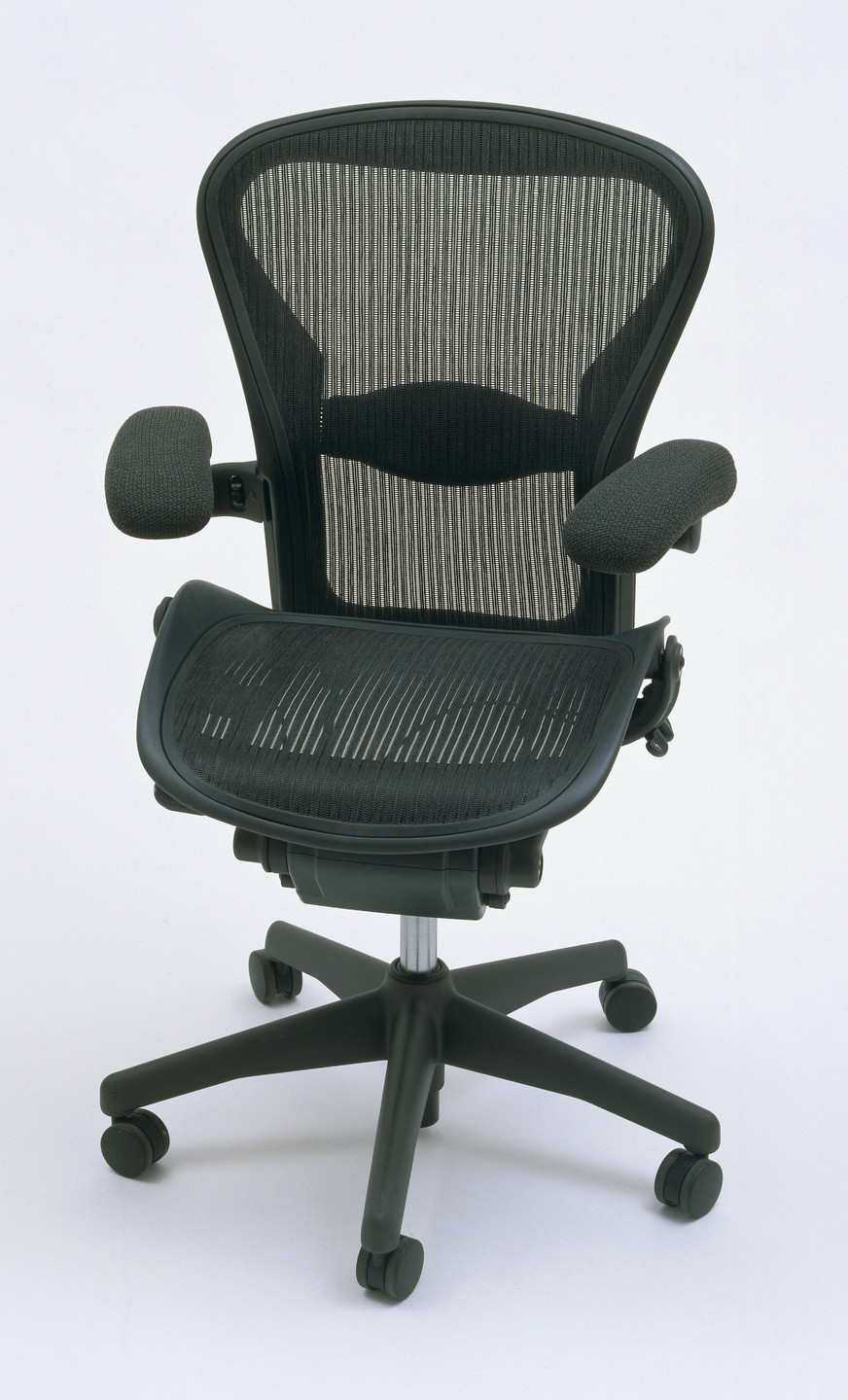 A modern office chair with a black mesh backrest, cushioned fabric armrests, and a black seat with ventilation holes. The chair has a five-wheel black base with a central silver support column. This is an AI generated description. To give feedback, email ai@moma.org.