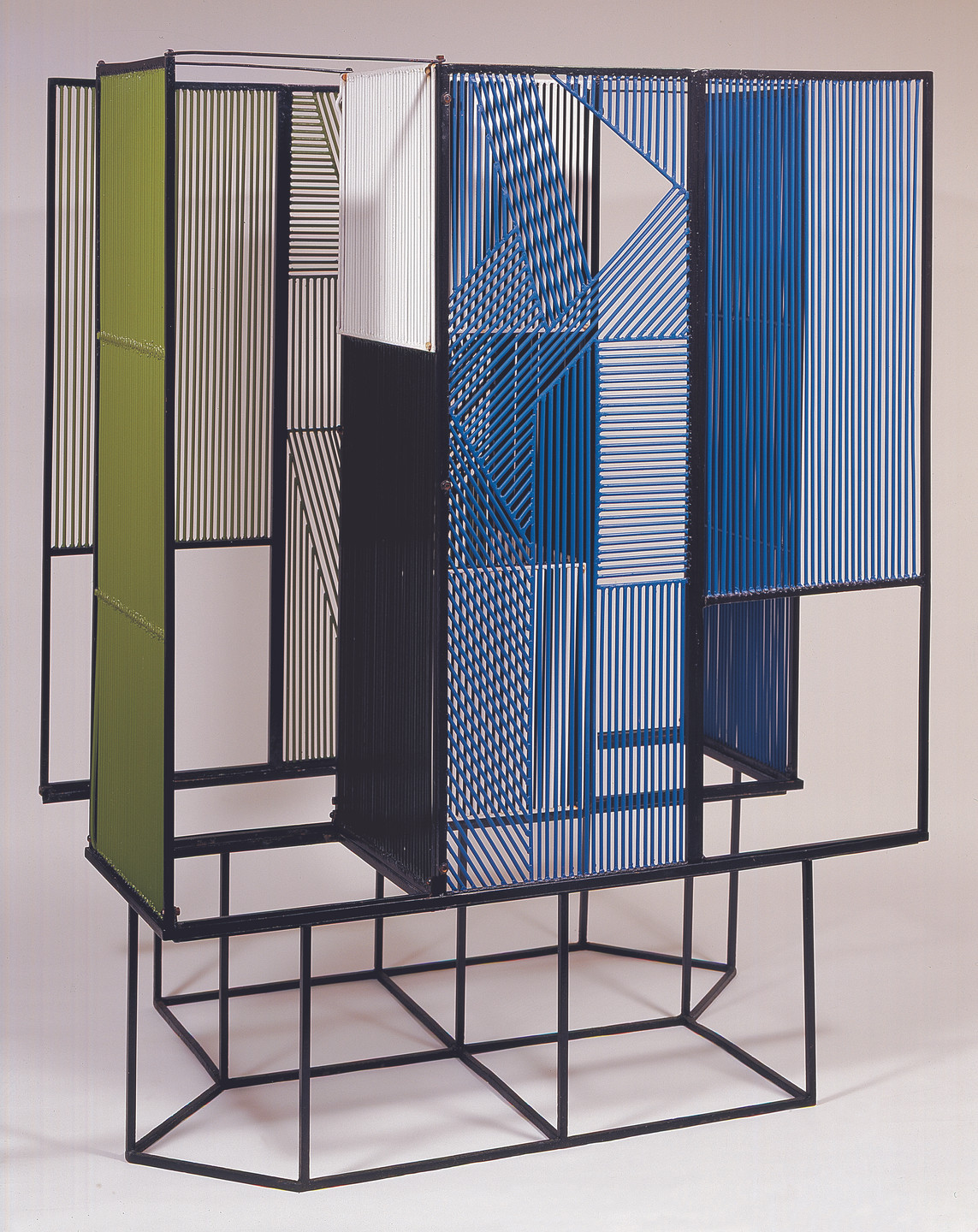 A geometric structure made of black metal rods features panels with vertical lines in green, white, black, and blue colors. The panels are arranged in a complex, layered composition. This is an AI generated description. To give feedback, email ai@moma.org.