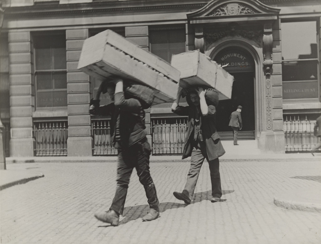 Market Porters Carrying Boxes of Oranges