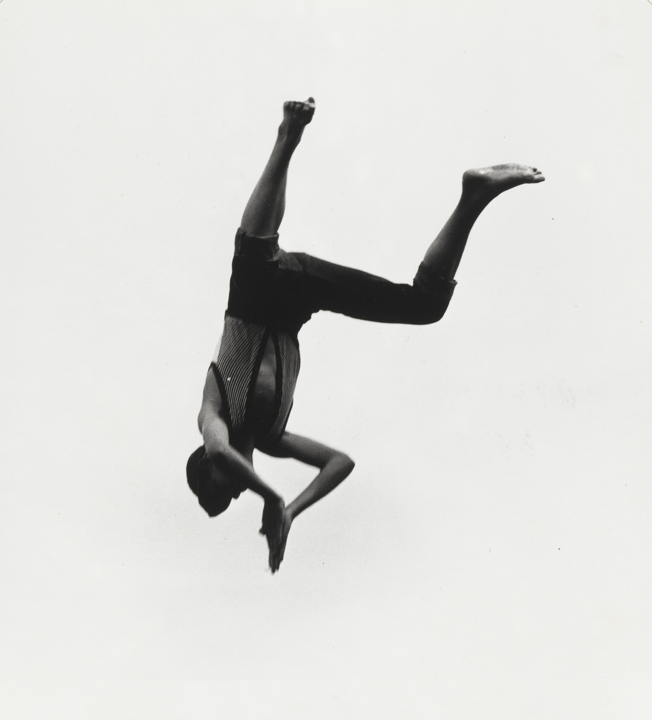 A person mid-air, legs bent and arms extended, against a white background. The clothing is striped on the torso and dark on the lower part. This is an AI generated description. To give feedback, email ai@moma.org.