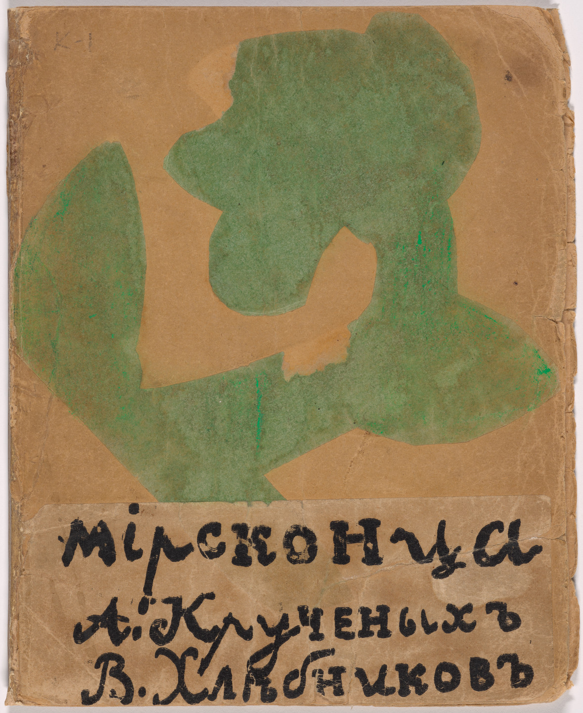 The image features a brown paper with an irregular green shape in the center. Below, there is black handwritten text in a non-English script on a lighter brown rectangular section. This is an AI generated description. To give feedback, email ai@moma.org.