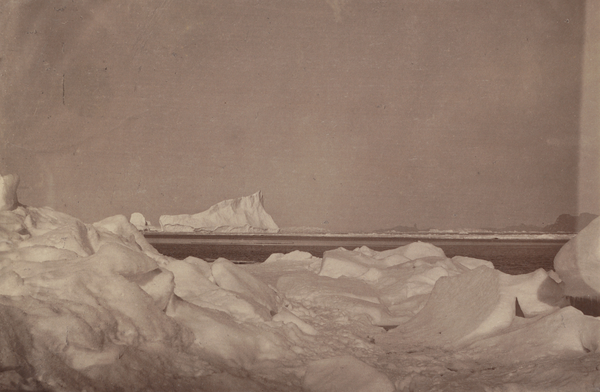 George P. Critcherson, John L. Dunmore, William Bradford. "Wilcox Point and the devil's thumb in the distance, with rafted ice in the Foreground. "
