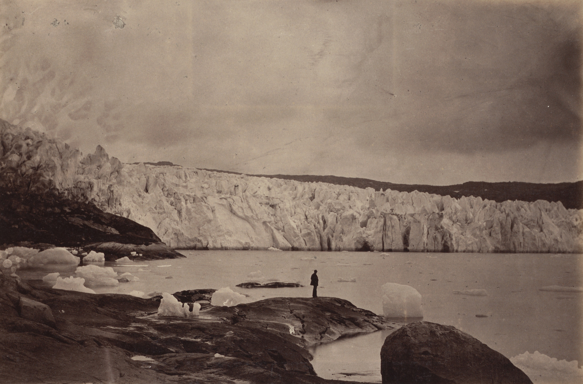 George P. Critcherson, John L. Dunmore, William Bradford. "The Glacier as seen forcing itself down over the land and into the waters of the Fiord. The Glacier seen at the left on the land is much finer rendered in the large upright view, No. 40."