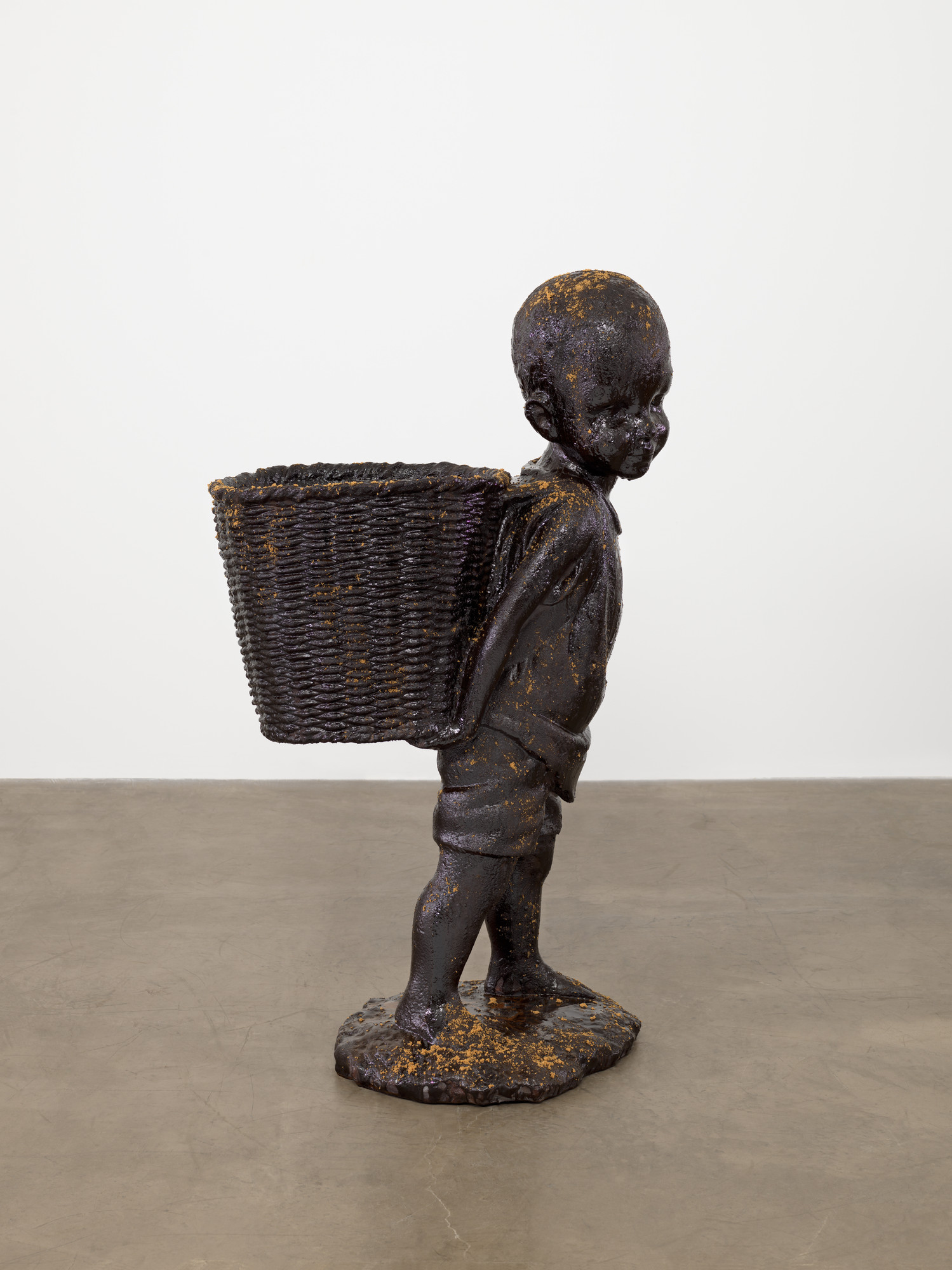 Kara Walker. African Boy Attendant Curio with Molasses and Brown Sugar, from "The Marvelous Sugar Baby" Installation at the old Domino Sugar Factory Warehouse. (Rear Basket)
