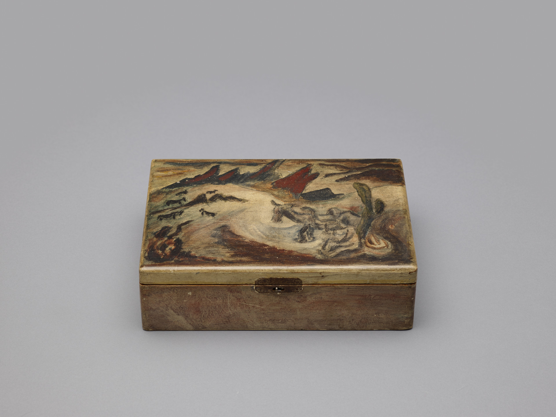A rectangular wooden box with a painted lid; the lid features muted colors, predominantly beige, brown, and green, depicting irregular shapes and soft, flowing lines. The box is closed and sits on a plain gray background. This is an AI generated description. To give feedback, email ai@moma.org.