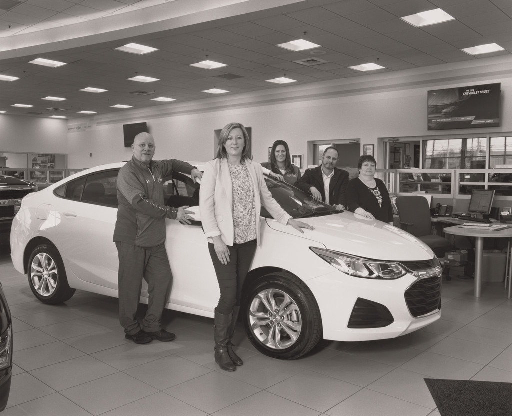 Sweeney Chevrolet Buick GMC car dealership Vice President Alexa Sweeney Blackann with Sales and Leasing Specialist Keith Burke, Product Specialists Debra DePaul and Elie Khoury, and Service Cashier Lisa Cartwright, standing with the last Cruze, Board-man, OH