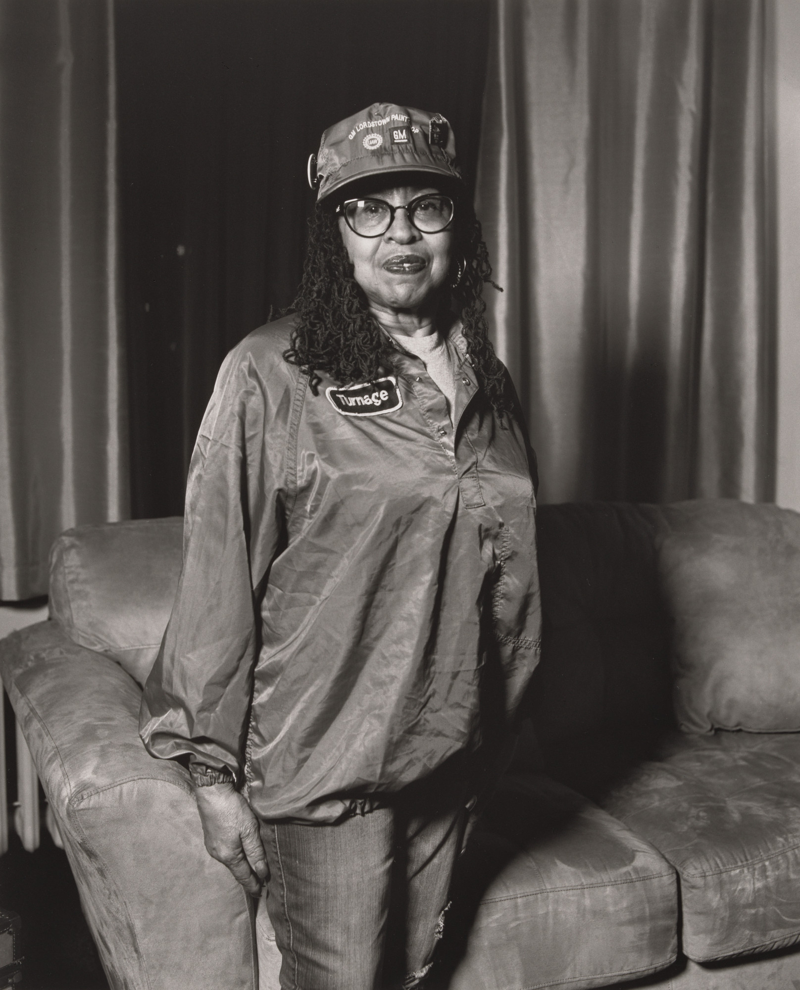 LaToya Ruby Frazier. Frances Turnage, UAW Local 1112, Women’s Committee, standing in her living room, wearing her work uniform (34 years in at GM Lordstown Complex, paint shop), Youngstown, OH.