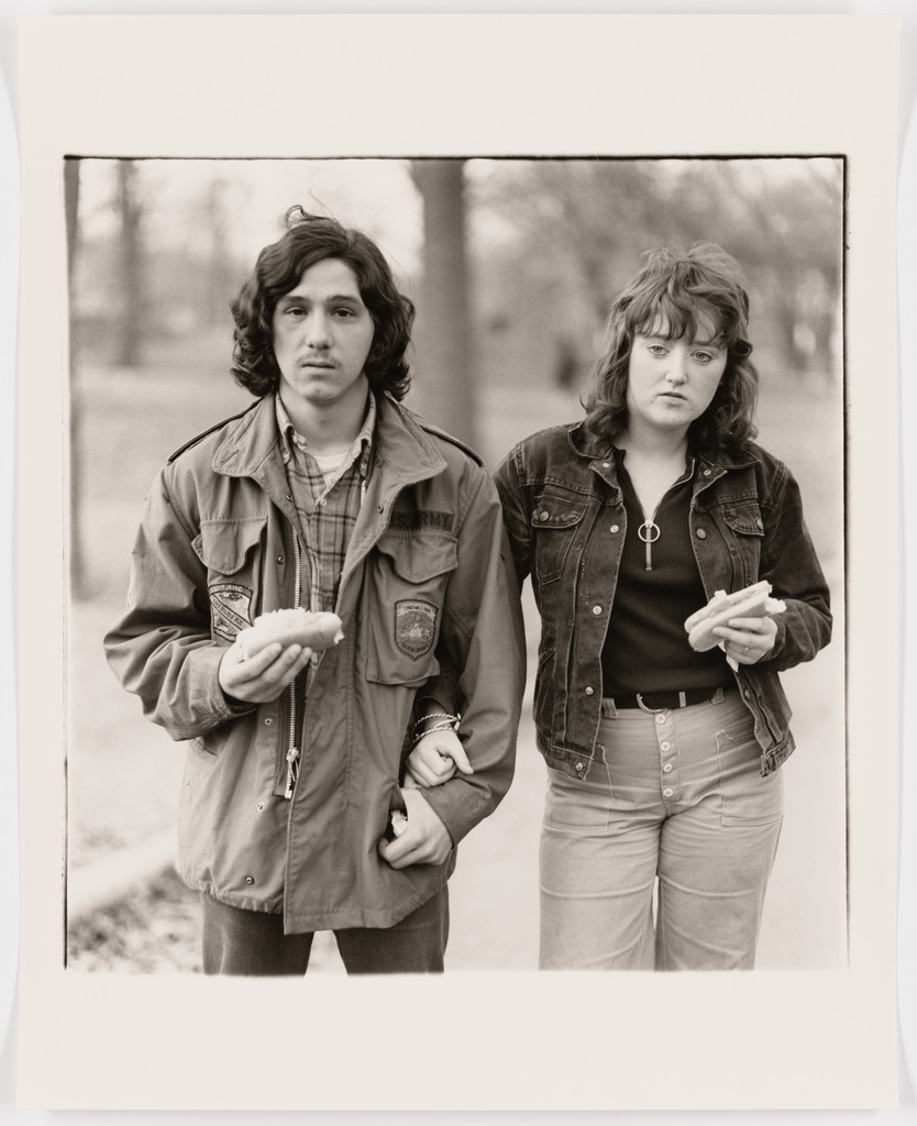 A young man and his girlfriend with hot dogs in the park, N.Y.C., 1971