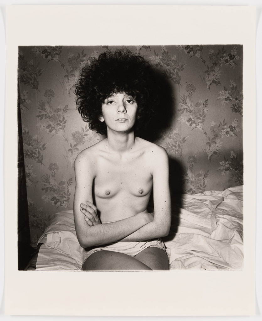 Girl sitting on her bed with her shirt off, N.Y.C., 1968