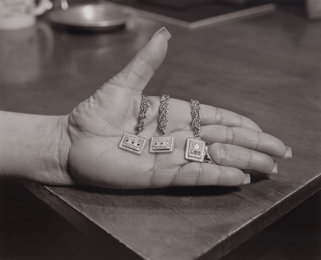 Frances Turnage, UAW Local 1112, Women’s Committee, holding her 10, 15, and 20 years of service General Motors company anniversary gold bracelets in her dining room, (34 years in at GM Lordstown Complex, paint shop) Youngstown, OH, 2019 from The Last Cruze