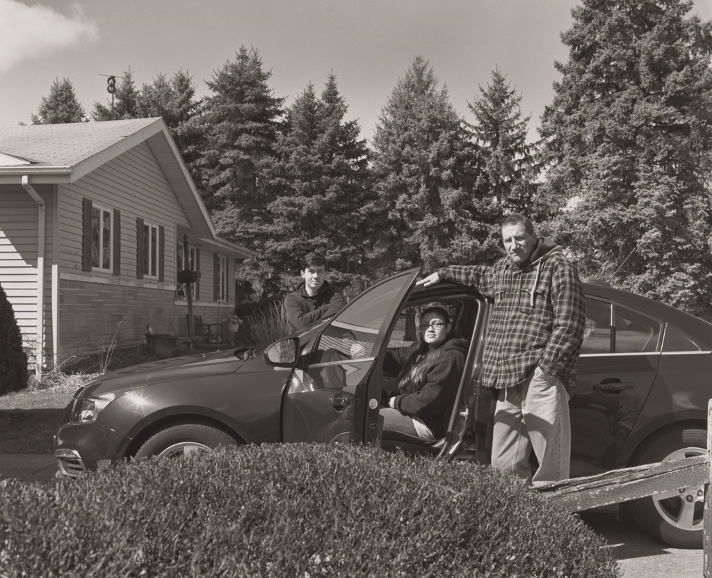 Jonathan Auckey, Jr., UAW Local 1112, with his wife and son, Monique and Michael, and the rainforest green, Chevrolet Cruze compact sedan he built and purchased for Monique, (19.5 years in at GM Lord-stown Complex, body shop), Austintown, OH., LaToya Ruby Frazier, 2019