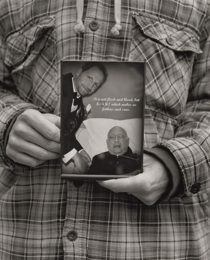 Jonathan Auckey, Jr., UAW Local 1112, holding the picture his mother Kathleen took of him on his wedding day with his father, Jonathan Auckey, Sr., (19.5 years in at GM Lordstown Complex body shop), Austintown, OH., LaToya Ruby Frazier, 2019