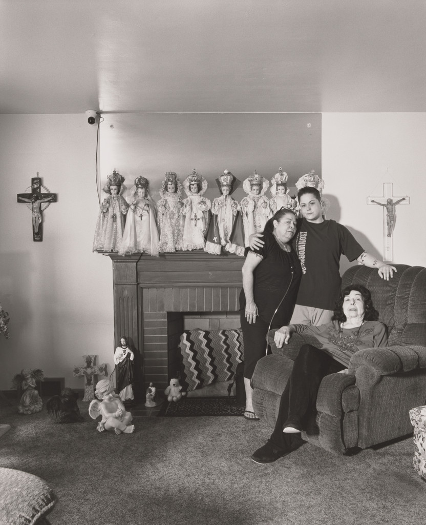 Mindy Miller, Iron Workers Union Local 851, standing in her grandmother’s living room with her mother and grandmother, Lezlie and Marlene Miller, [11 years in at Auto Warehouse Company (AWC)], Niles, OH, LaToya Ruby Frazier, 2019