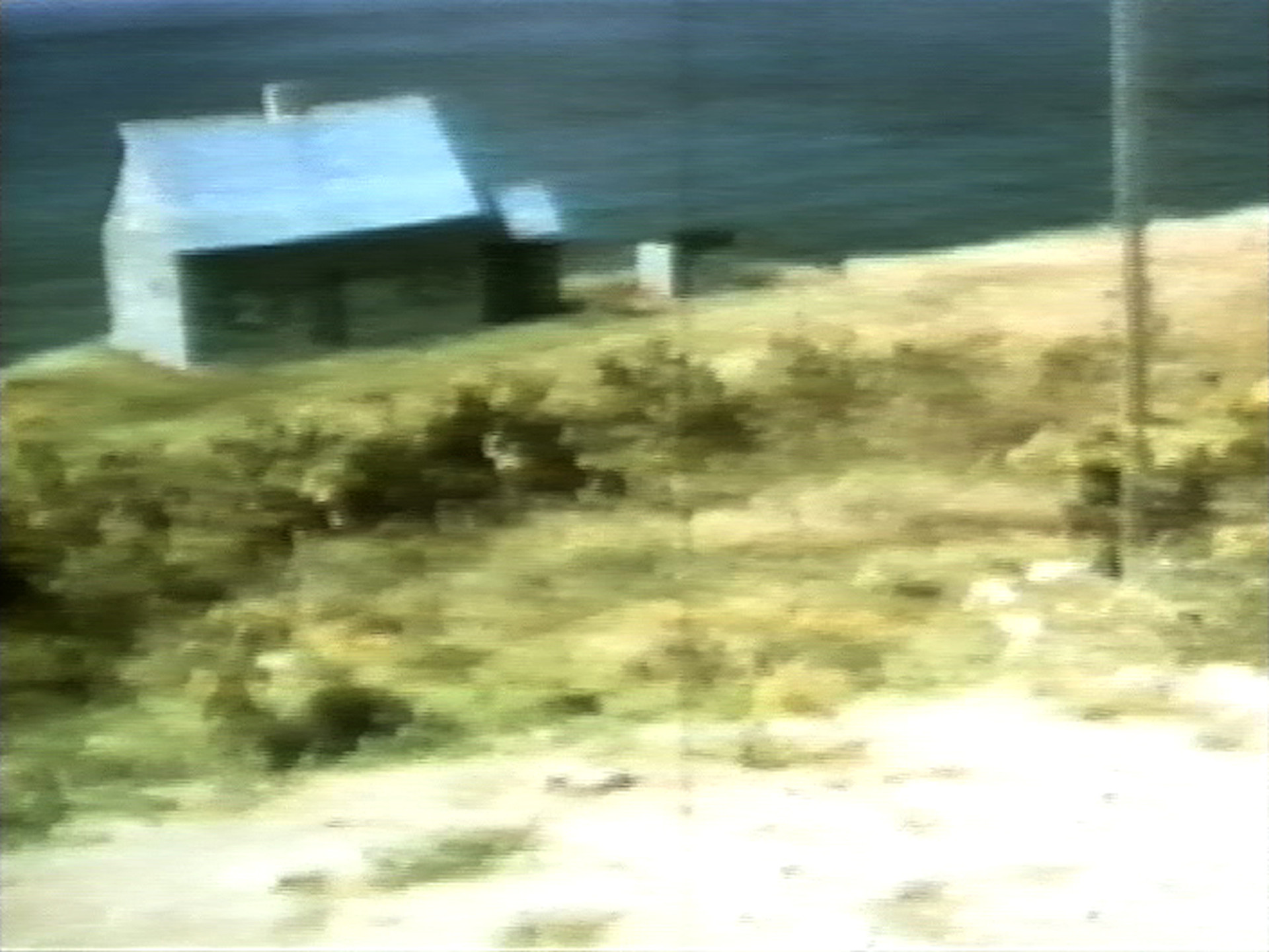 A small gray building with a sloped roof sits on a grassy field near a body of water. The foreground features a mix of green and brown vegetation under a pale sky. This is an AI generated description. To give feedback, email ai@moma.org.