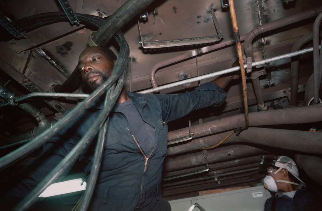 Pipe fitters finishing the engine room of a tuna-fishing boat. Campbell Shipyard. San Diego harbor from the series Fish Story