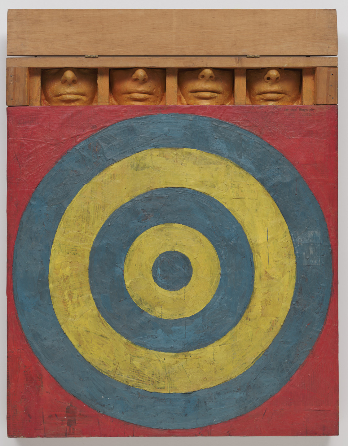 The image features a red background with a large yellow and blue concentric circle target in its center. Along the top edge, there are five partially visible, painted faces with closed eyes. This is an AI generated description. To give feedback, email ai@moma.org.