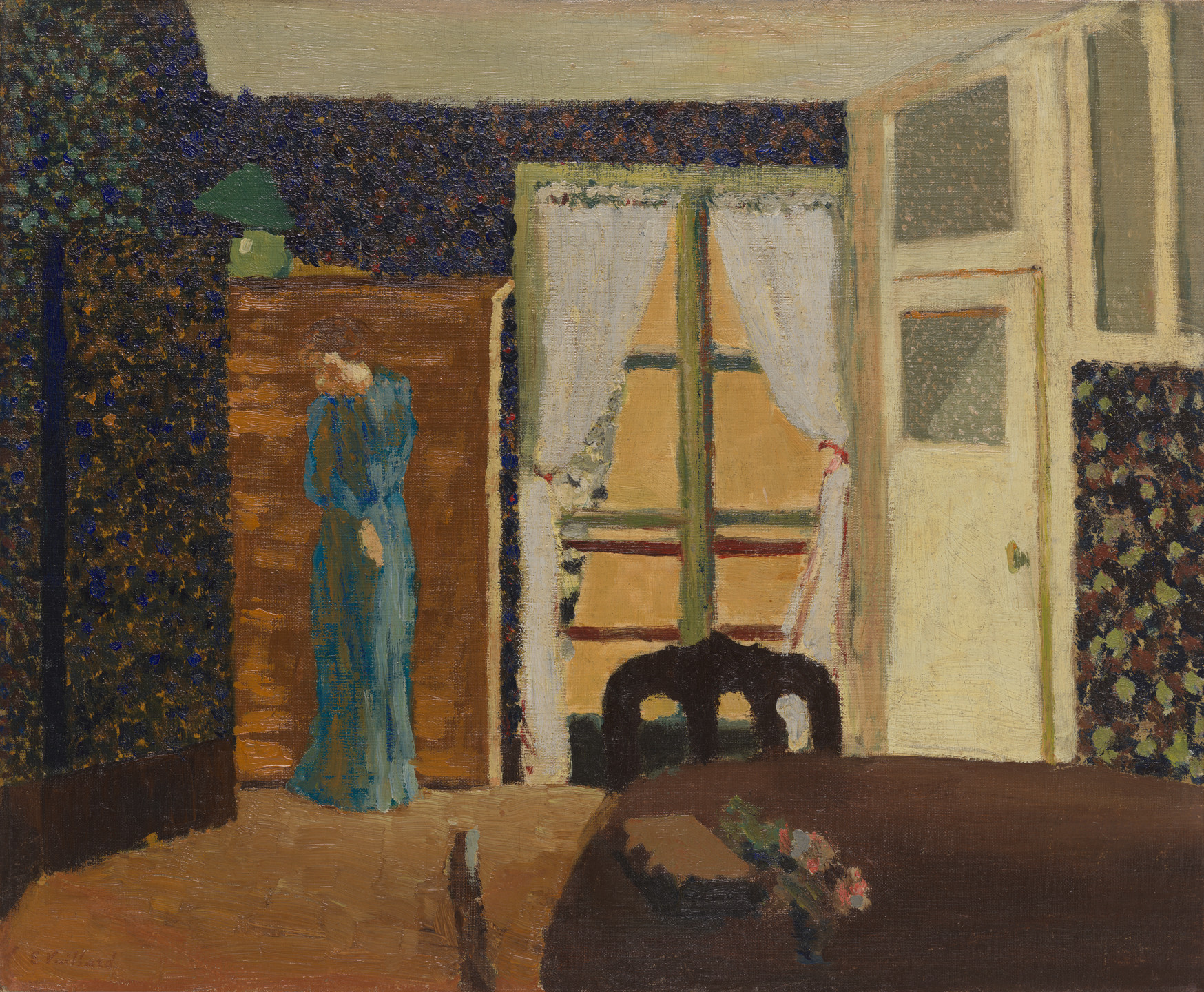 The image depicts an interior room with dark, textured walls and a wooden door, partially open. A figure in a blue garment stands near a green lamp and a set of double windows with sheer curtains. This is an AI generated description. To give feedback, email ai@moma.org.