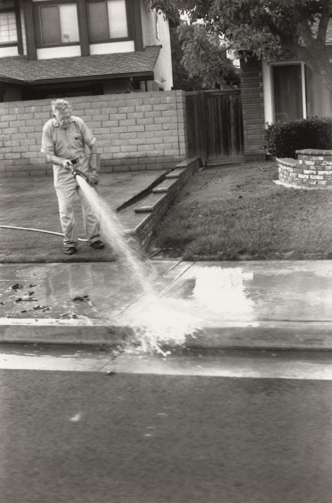 Huntington Beach (Man waters sidewalk)