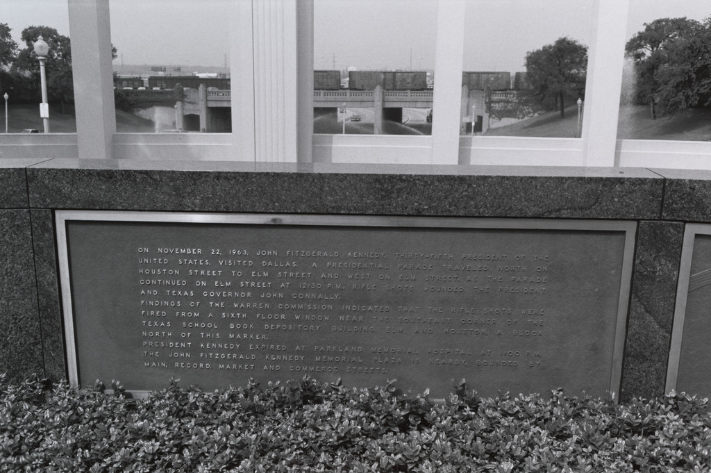 Dallas (JFK memorial plaque on wall: bridge in background)