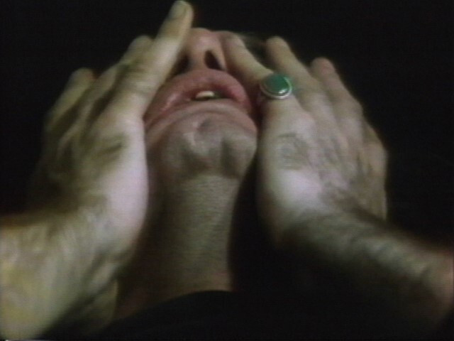Vito Acconci's Face of the Earth: video still showing extreme close-up of artist's face with hands touching it