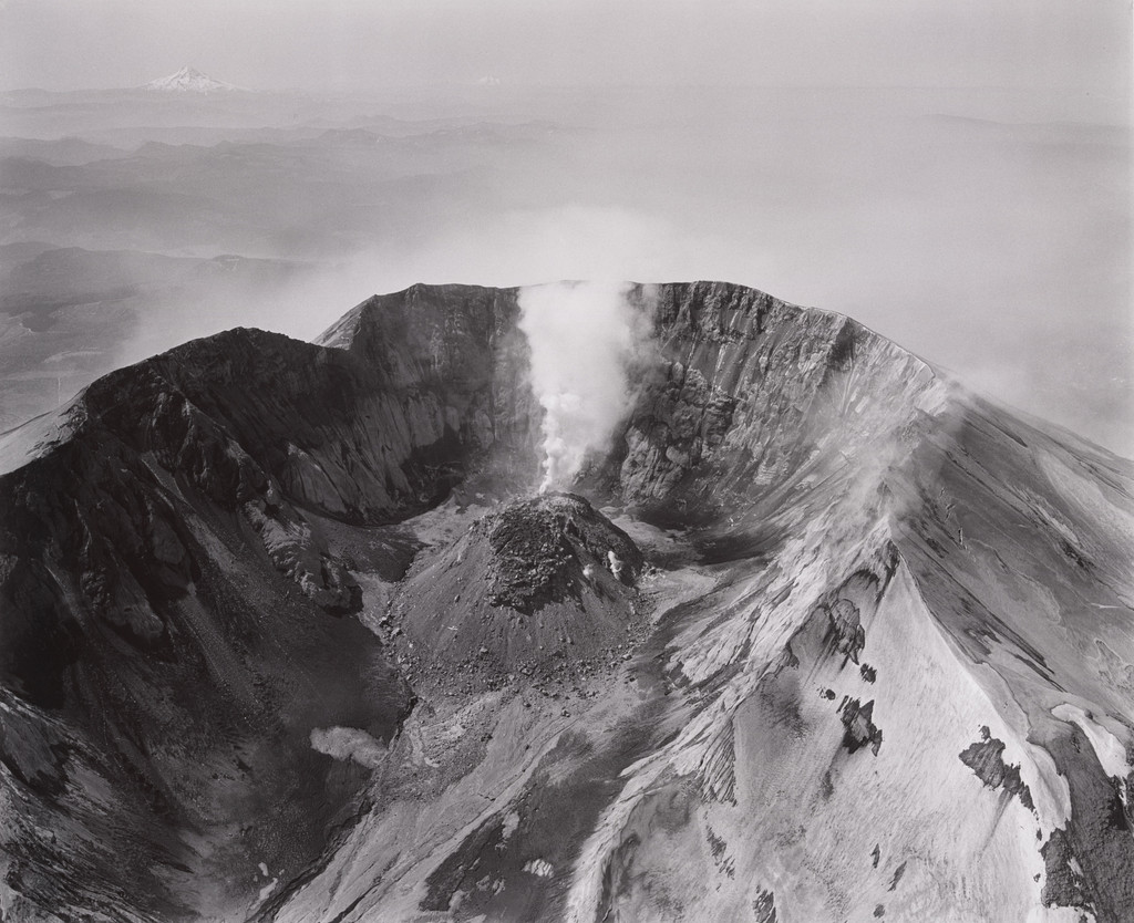 Aerial view: looking south at Mount St. Helens crater and lava dome, Mount Hood and Mount Jefferson in the distance, airplane in crater