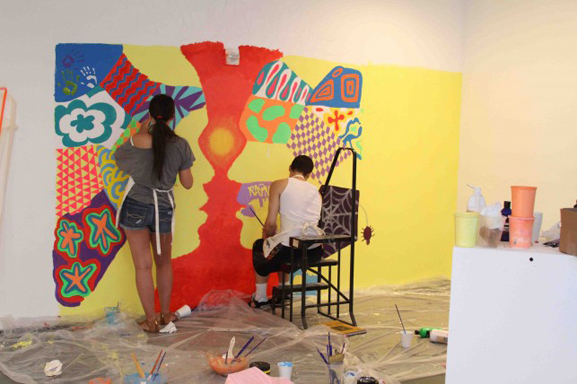 Teens working on the main mural prior to putting up the rock walls