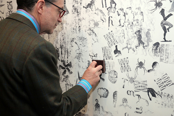 Visitor at MoMA Studio: Beyond the Cut-out, contributing to Carlos Amorales's interactive installation "Stamping a Collective Mural." Photo: Manuel Molina Martagon, 2014
