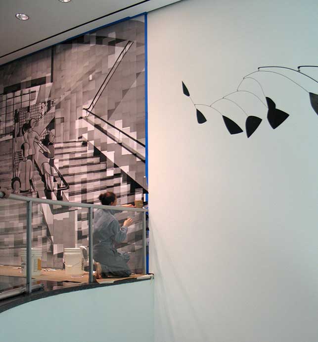 Katharina Gaenssler at work, October 30, 2015. The final steps involved Gaenssler adding paper sheets all the way to the edge of the space, then trimming the excess. Also visible: Alexander Calder. Lobster Trap and Fish Tail. Roxbury, Connecticut, 1939. Painted steel wire and sheet aluminum, 8' 6" (260 cm) x 9' 6" (290 cm) in diameter. The Museum of Modern Art, New York. Commissioned by the Advisory Committee for the stairwell of the Museum. Photo: Kristen Gaylord
